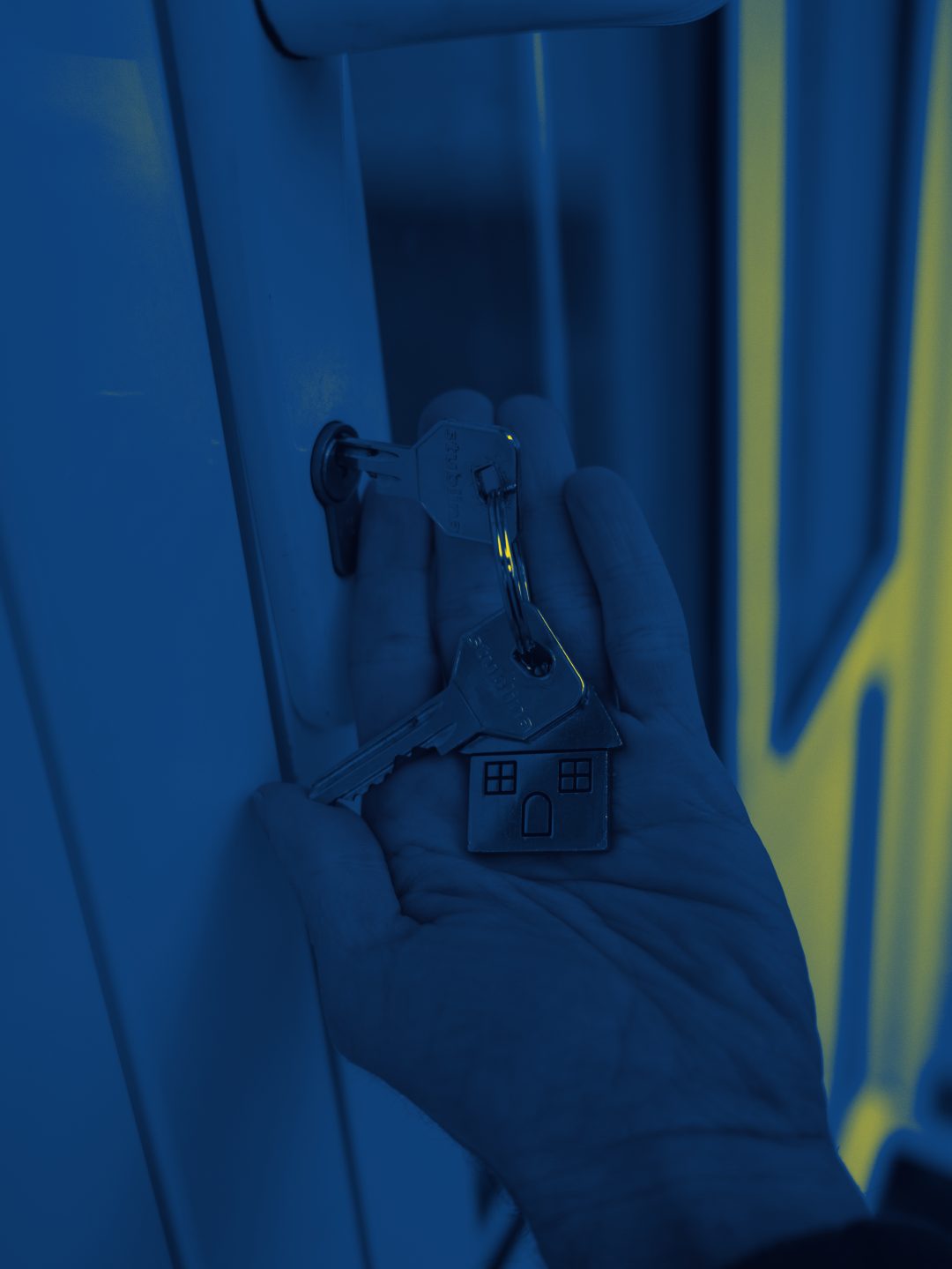 Una mano infila la chiave nella serratura di una porta di casa